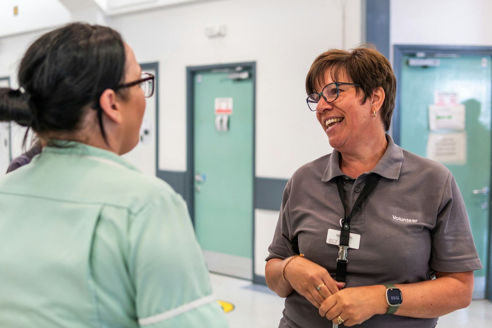 Twee collega’s lachen samen in een gang